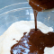 pouring chocolate mixture over the dry ingredients