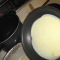 swirling gluten free crepe batter in the pan